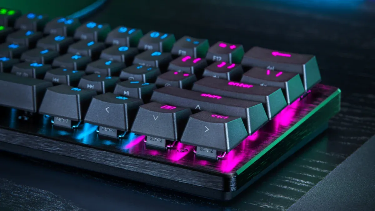 Compact black keyboard with vibrant RGB backlighting, angled keys, and a sleek carbon-fiber textured base.