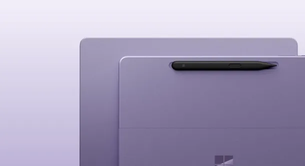 Two lavender Surface devices with a stylus in the kickstand and a dark gray mouse beside them.