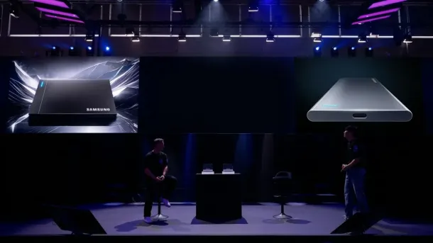 Two presenters on stage with large screens displaying black and silver Samsung portable SSDs under purple and blue lighting.