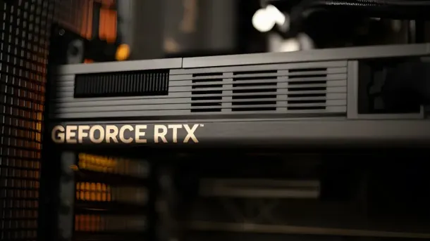 Close-up of a silver GeForce RTX graphics card with ventilation grilles, installed in a computer case.